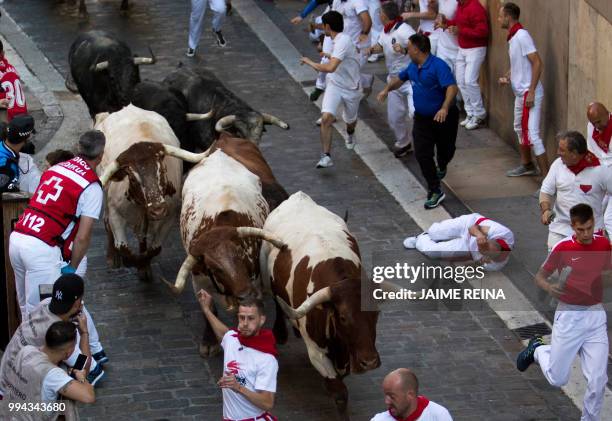 Participants run next to Cebada Gago fighting bulls on the third day of the San Fermin bull run festival in Pamplona, northern Spain on July 9, 2018....