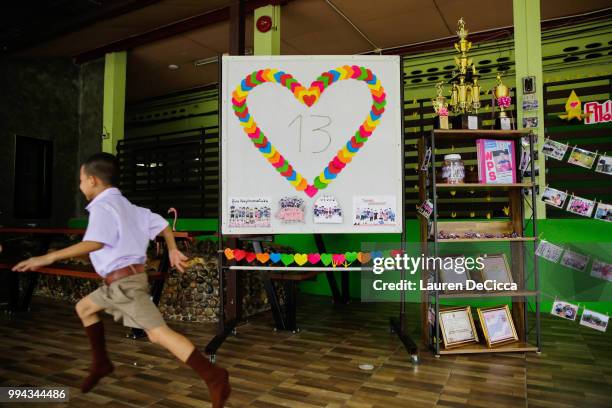 Classmates of Adul, one of the boys trapped in Tham Luang Nang Non cave, visit a tribute for the Wild Boars soccer team at the entrance of Ban...