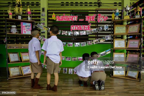 Classmates of Adul, one of the boys trapped in Tham Luang Nang Non cave, visit a tribute for the Wild Boars soccer team at the entrance of Ban...
