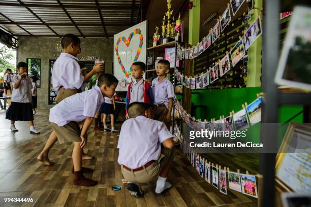 Classmates of Adul, one of the boys trapped in Tham Luang Nang Non cave, visit a tribute for the Wild Boars soccer team at the entrance of Ban...