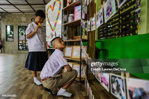 Classmates of Adul, one of the boys trapped in Tham Luang Nang Non cave, visit a tribute for the Wild Boars soccer team at the entrance of Ban...