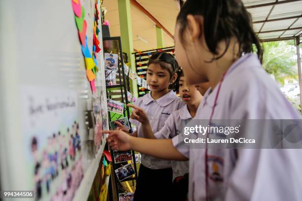 Classmates of Adul, one of the boys trapped in Tham Luang Nang Non cave, visit a tribute for the Wild Boars soccer team at the entrance of Ban...