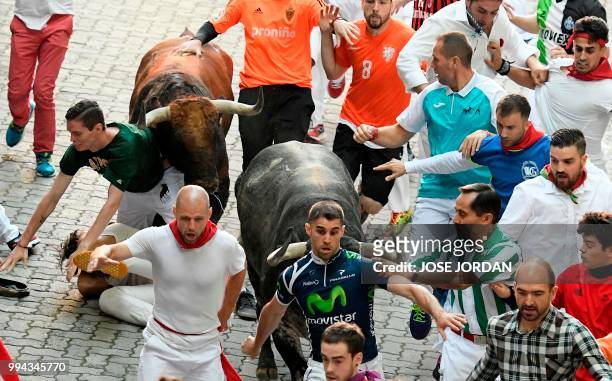 Participants run next to Cebada Gago fighting bulls on the third day of the San Fermin bull run festival in Pamplona, northern Spain on July 9, 2018....