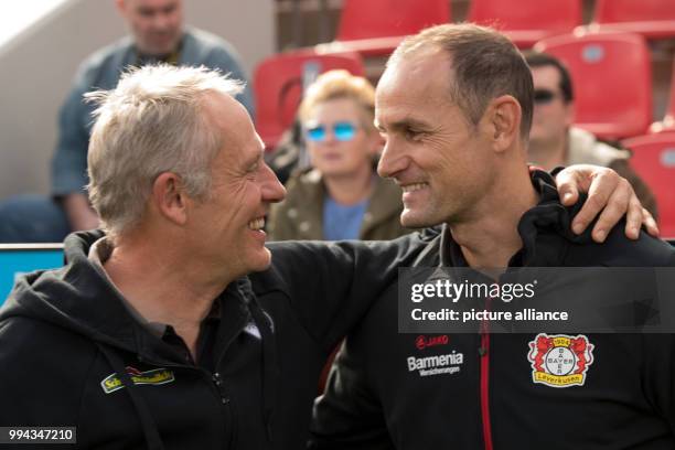 Leverkusen's coach Heiko Herrlich and Freiburg's coach Christian Streich hug each other prior to the German Bundesliga soccer match between Bayer...