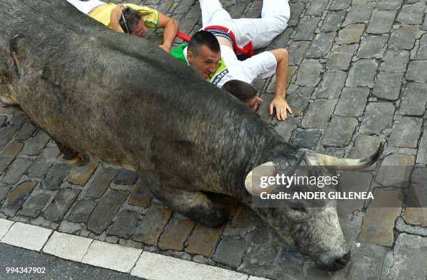 Participants enter the bullring with a Cebada Gago fighting bull on the third day of the San Fermin bull run festival in Pamplona, northern Spain on...