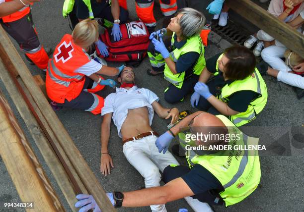 Participant receives medical assistance on the third day of the San Fermin bull run festival in Pamplona, northern Spain on July 9, 2018. - Each day...