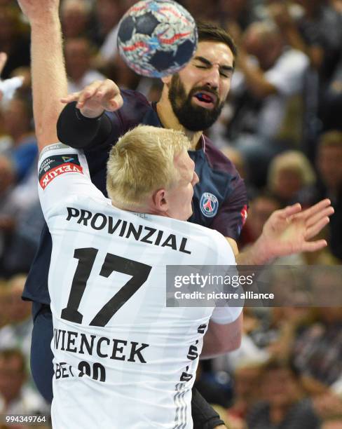 Nikola Karabatic of Paris Saint-Germain and Kiel's Patrick Wiencek vie for the ball during the Champions League Group B handball match between THW...