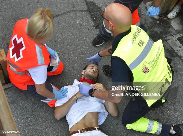 Participant receives medical assistance on the third day of the San Fermin bull run festival in Pamplona, northern Spain on July 9, 2018. - Each day...