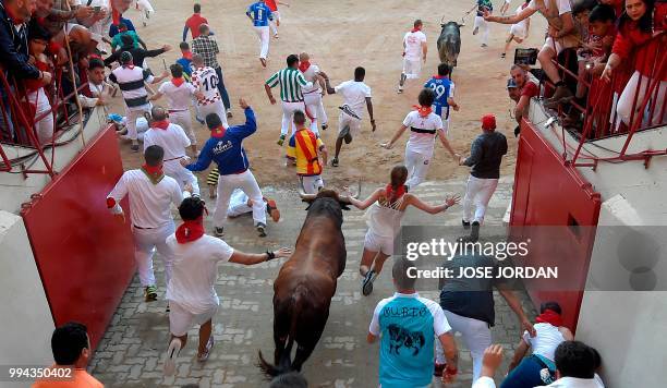 Participants enter the bullring with Cebada Gago fighting bulls on the third day of the San Fermin bull run festival in Pamplona, northern Spain on...