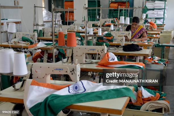 This photo taken on May 9, 2018 shows an employee of Khadi Gramodyog Samyukta Sangh stitching together an Indian national flag at the Indian National...