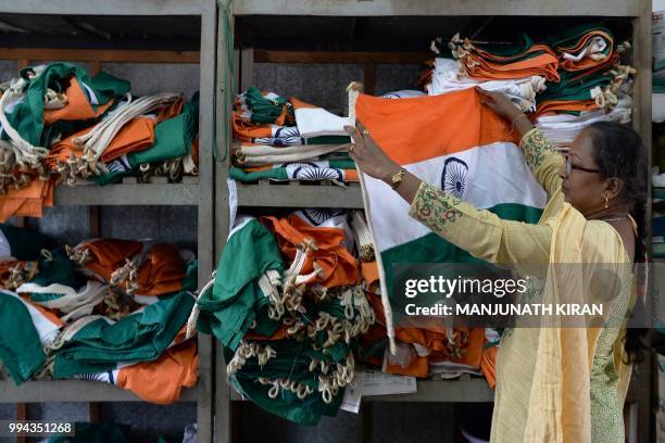 This photo taken on May 9, 2018 shows an employee of Khadi Gramodyog Samyukta Sangh checking Indian national flags at the Indian National Flag...