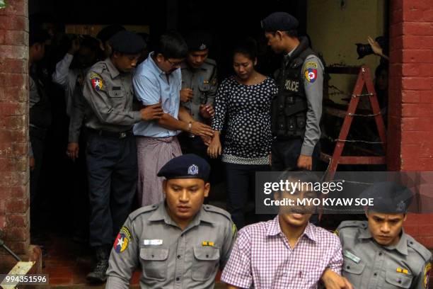 Detained Myanmar journalists Kyaw Soe Oo and Wa Lone are escorted by police from a courthouse following their ongoing pre-trial hearing in Yangon on...
