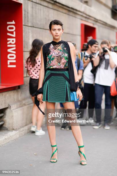 Model Georgia Fowler wears a mesh lace top with colored embroidered flowers, a green skirt, outside Elie Saab, during Paris Fashion Week Haute...