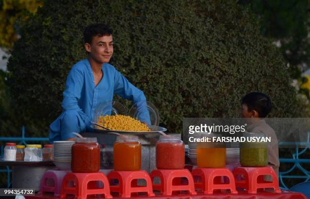 In this photo taken on July 8, 2018 an Afghan vendor looks on as he sells chickpeas in the courtyard of Hazrat-e-Ali shrine or Blue Mosque, in...