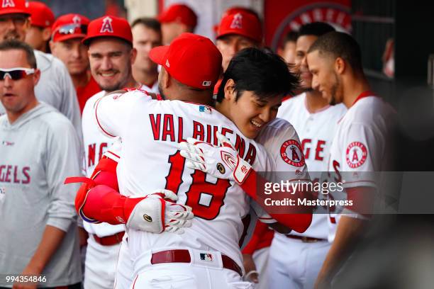 Shohei Ohtani of the Los Angeles Angels of Anaheim celebrates with Luis Valbuena after he hits a solo home run during the MLB game against the Los...