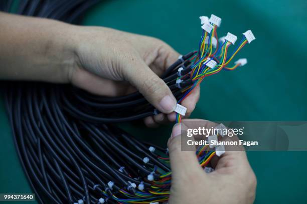 hands of worker with electrical cords at an electronics factory in dongguan, china - callus stock pictures, royalty-free photos & images
