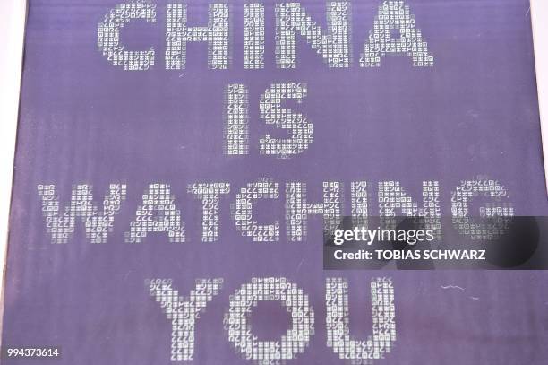 Computer monitor with the words 'China is watching you' is pictured during a demonstration of activists of the 'Society for Threatened Peoples' next...