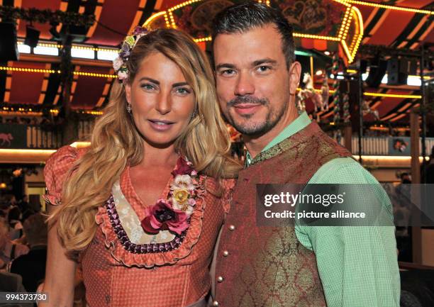 DJane Giulia Siegel and her partner Ludwig Heer pose at the Bild Wiesn regulars' table inside the Marstall festive tent at the Oktoberfest in Munich,...