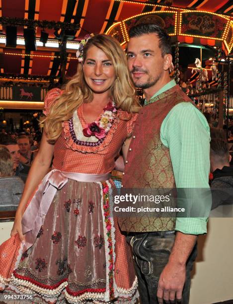 DJane Giulia Siegel and her partner Ludwig Heer pose at the Bild Wiesn regulars' table inside the Marstall festive tent at the Oktoberfest in Munich,...