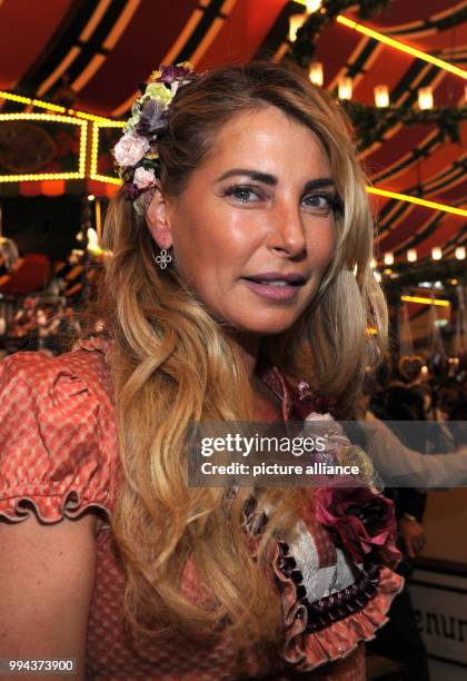 DJane Giulia Siegel smiles on a photograph at the Bild Wiesn regulars' table inside the Marstall festive tent at the Oktoberfest in Munich, Germany,...