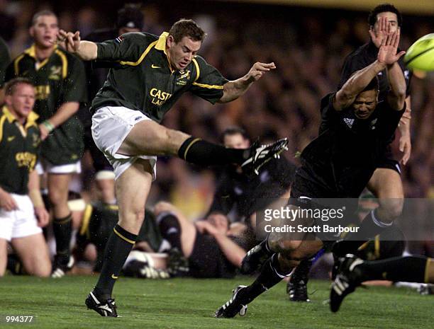 Butch James of South Africa gets a kick away despite Pita Alatini of the All Blacks charge down attempt during the Tri Nations match between New...