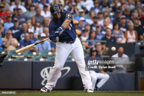 Jesus Aguilar of the Milwaukee Brewers hits a sacrifice fly in the first inning against the Atlanta Braves at Miller Park on July 5, 2018 in...