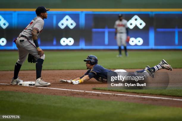 Hernan Perez of the Milwaukee Brewers slides into third base for a triple past Johan Camargo of the Atlanta Braves in the second inning at Miller...