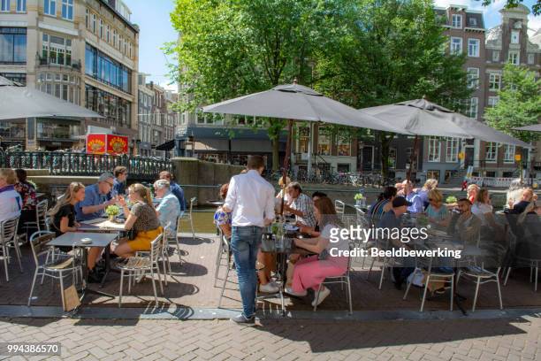 dining and having a drink in leidsestraat amsterdam - waterfront cafe stock pictures, royalty-free photos & images