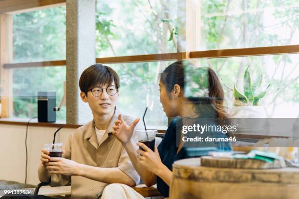 young men and woman discussing at the cafe. - youth coalition stock pictures, royalty-free photos & images