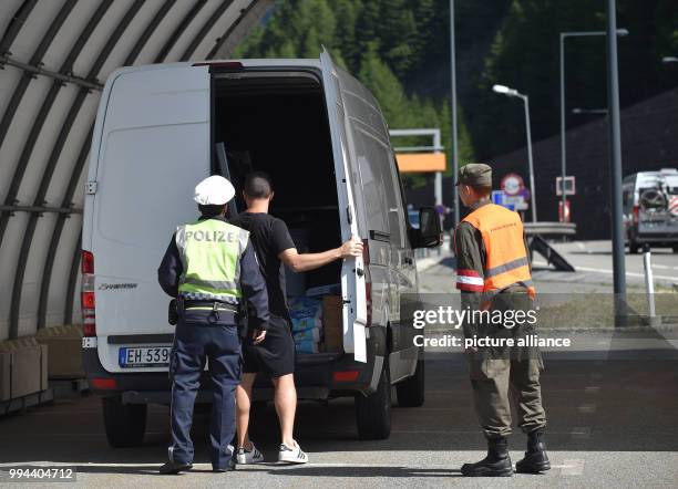 July 2018, Austria, Brenner Pass: Police officers check the entry of vehicles from Italy to Austria at the Brenner Pass. During night time, the check...