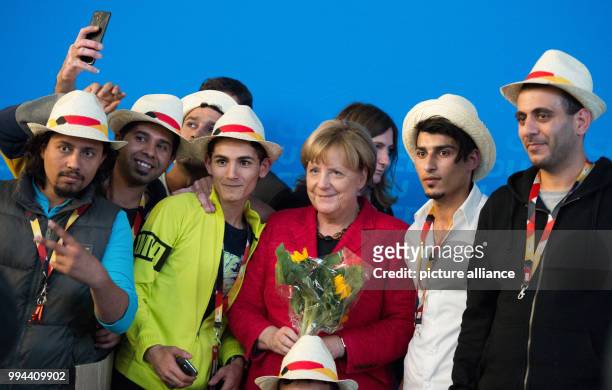 German Chancellor Angela Merkel takes pictures with Syrian refugees at a campaign event of Mecklenburg-Western Pomerania's Christian Democratic Union...