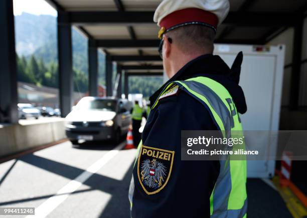 July 2018, Austria, Brenner Pass: Austrian police officers check the entry of vehicles from Italy to Austria at the Brenner Pass. During night time,...