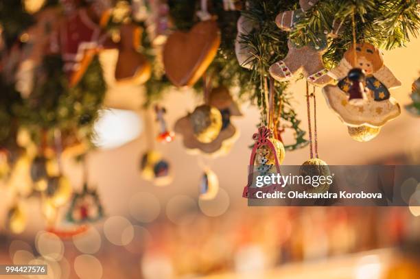 holiday ornaments, gilded walnuts and gingerbread cookies hanging during a holiday market. - berlin christmas stock pictures, royalty-free photos & images