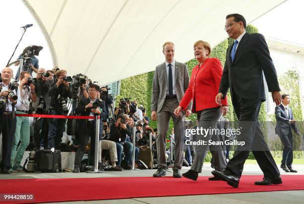 German Chancellor Angela Merkel and Chinese Premier Li Keqiang walk past photographers upon Li's arrival at the Chancellery on July 9, 2018 in...