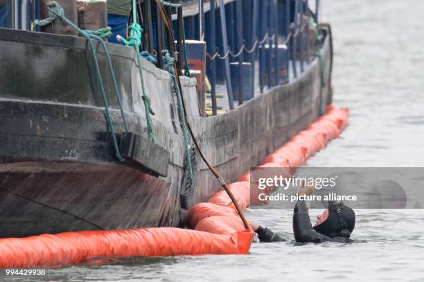Dpatop - A diver beside a freight barge on the River Danube in Straubing, Germany, 20 September 2017. After a leak in the engine room, the fire...