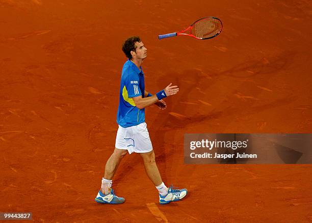 Andy Murray of Great Britain throws his racket after loosing a game in his quarter final match against David Ferrer of Spain during the Mutua...