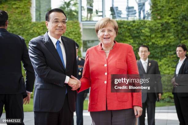 Li Keqiang, China's premier, left, shakes hands with Angela Merkel, Germany's chancellor, as he arrives at the Chancellery building in Berlin,...