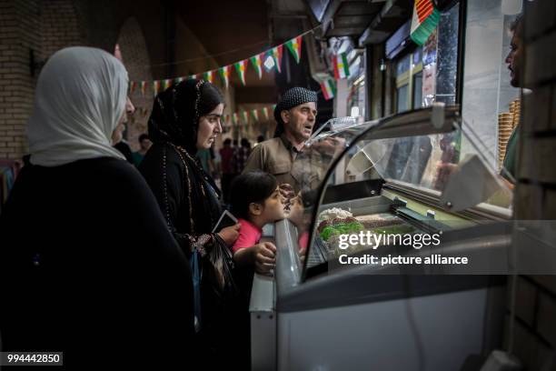 Dpatop - A Kurdish family buys ice cream on a market decorated with the Kurdish flag in Erbil, Iraq, 20 September 2017. Erbil is one of the cities...