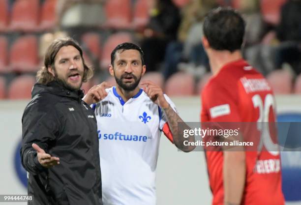 Darmstadt's Torsten Frings and Aytac Sulu discuss with Heidenheim's Norman Theuerkauf during the German Second Bundesliga soccer match between 1. FC...