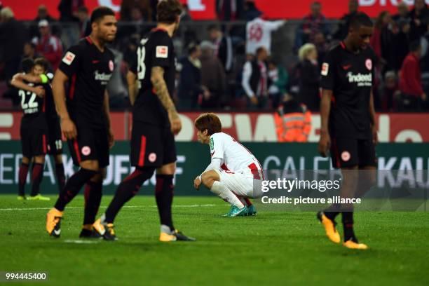 Cologne's Yuya Osako sits on the ground after the defeat after the German Bundesliga soccer match between 1. FC Cologne and Eintracht Frankfurt in...