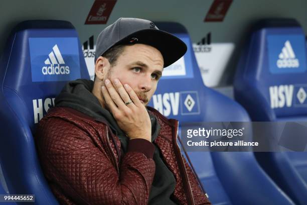 Hamburg's injured forward Nicolai Mueller sits on the bench during the German Bundesliga soccer match between Hamburger SV and Borussia Dortmund in...