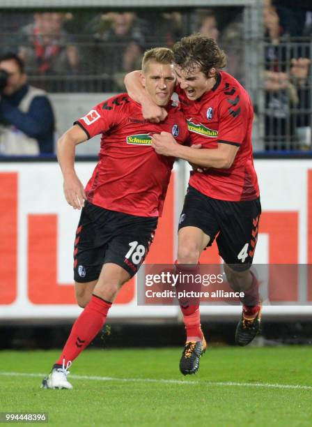 Freiburg's Nils Petersen celebrates with teammate Caglar Söyüncü after levelling the score at 1:1 during the German Bundesliga soccer match between...