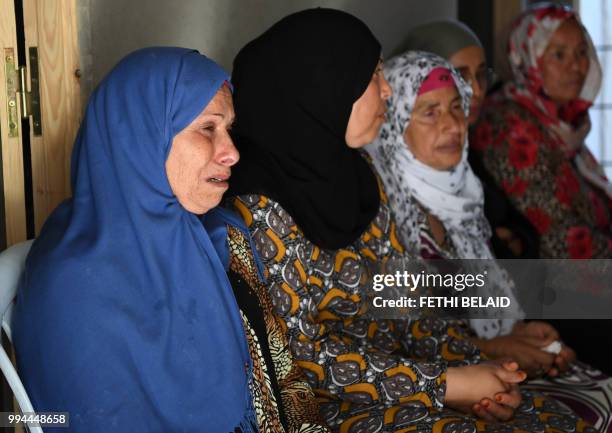 Relatives of killed Tunisian police officer Sgt. Arbi Guizani mourn over his coffin in their home in the capital Tunis' northwestern suburb of...