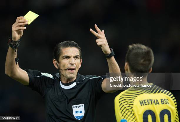 Referee Deniz Aytekin shows Hertha's keeper Rune Jarstein the yellow card for time-wasting during the German Bundesliga soccer match between Hertha...
