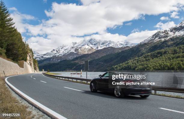 An open-top car drives along an Alpine road in Maloja, Switzerland, 20 September 2017. Photo: Lino Mirgeler/dpa