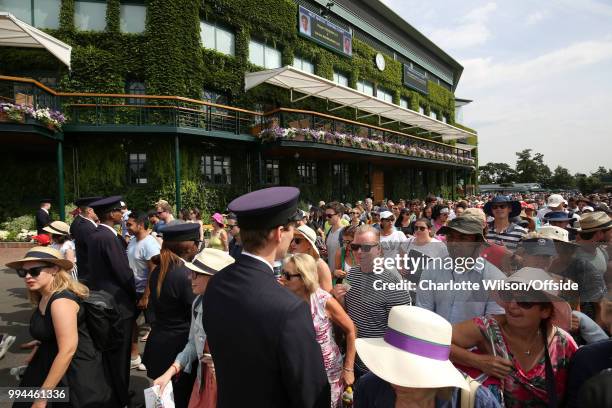 Crowd of spectators makes their way into the grounds after being lead in by security at All England Lawn Tennis and Croquet Club on July 9, 2018 in...