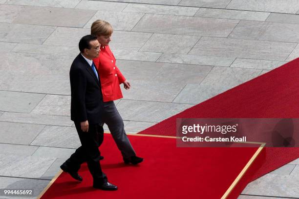 German Chancellor Angela Merkel and Chinese Premier Li Keqiang walk to the honor guard during the welcome ceremony at the Chancellery on July 9, 2018...