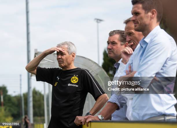 July 2018, Germany, Dortmund: Lucien Favre , coach of Borussia Dortmund, leads the first training session of his team while sporting director Michael...