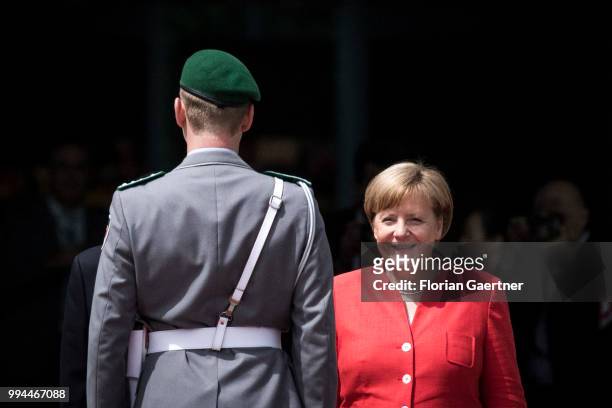 German Chancellor Angela Merkel is pcitured in front of a soldier during the meeting with Li Keqiang , Prime Minister of China, on July 09, 2018 in...