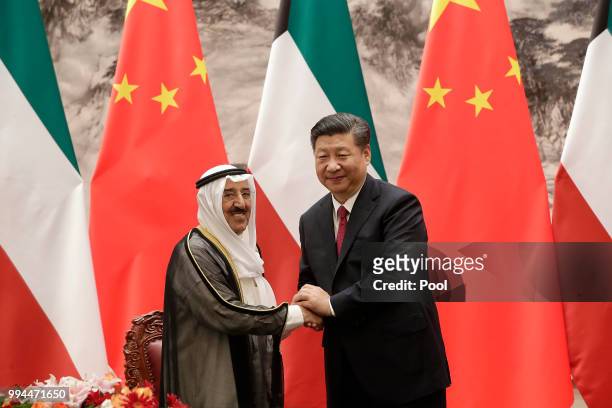 Kuwait's ruling emir, Sheikh Sabah Al Ahmad Al Sabah shakes hands with Chinese President Xi Jinping after witnesses a signing ceremony at the Great...